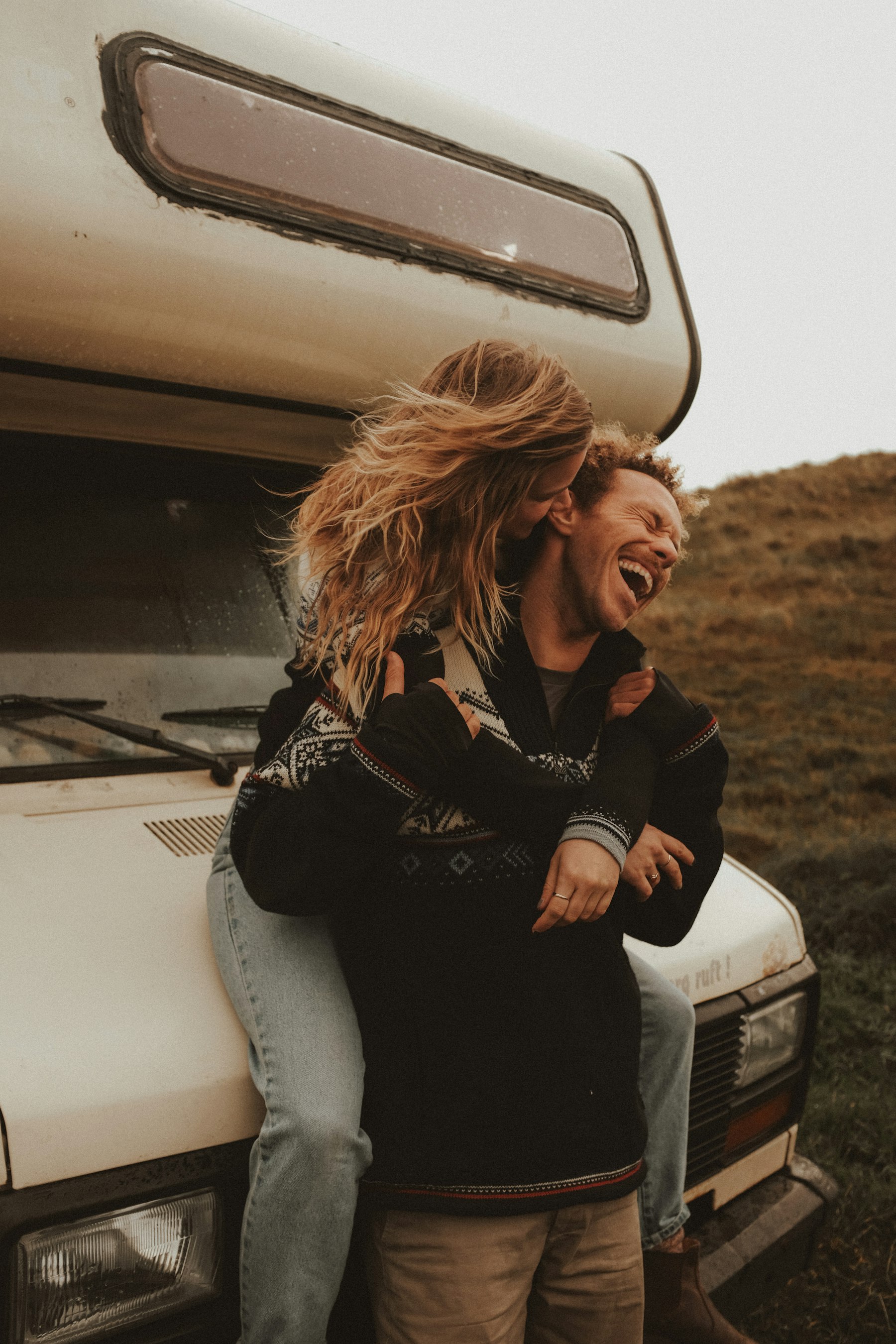 Two friends laughing together on a road trip